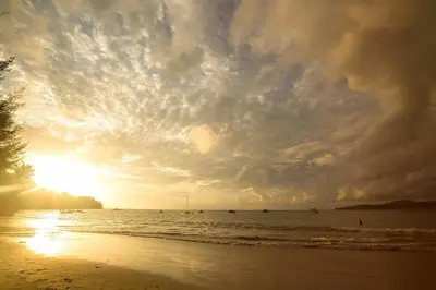 a sunset on the beach with boats in the water at 5 bdr Pool Villa Bang Tao Beach in Laguna Phuket