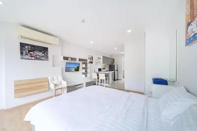 a white bedroom with a white bed and a desk at Beach Life & Surf Thrills, Stay at Kata Suite 8-132 in Kata Oasis Residence in Kata Beach