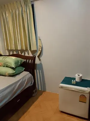 a bedroom with a bed with a trunk next to it at Lucky Guest house in Karon Beach