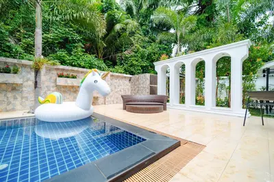 a pool with a plastic horse float next to a patio at Rich Pool Villa Phang Nga in Khok Kloi