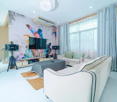 a living room with two white couches and a tv at Rich Pool Villa Phang Nga in Khok Kloi