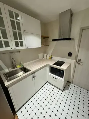 a small kitchen with white cabinets and a sink at Super Naiyang Title 1Bdr 600m to beach in Nai Yang Beach