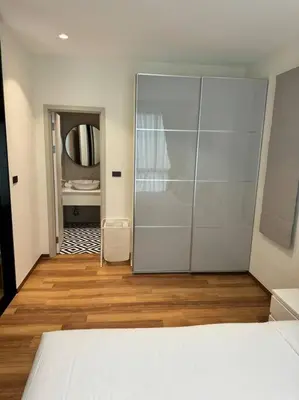a bedroom with a bed and a bathroom with a mirror at Super Naiyang Title 1Bdr 600m to beach in Nai Yang Beach