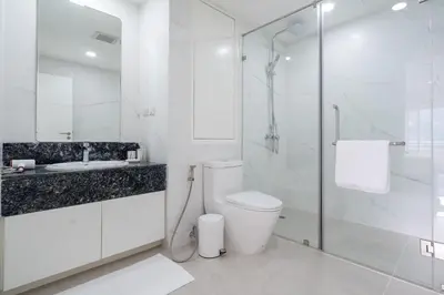 a white bathroom with a toilet and a glass shower at Patong Tower Brand 1-Bedroom apartment mountain view , Near Beach in Patong Beach