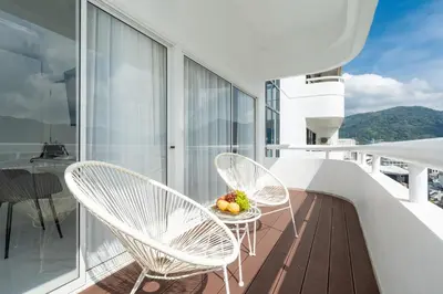 a balcony with two chairs and a bowl of fruit at Patong Tower Brand 1-Bedroom apartment mountain view , Near Beach in Patong Beach