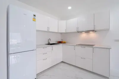 a white kitchen with white cabinets and a sink at Patong Tower Brand 1-Bedroom apartment mountain view , Near Beach in Patong Beach