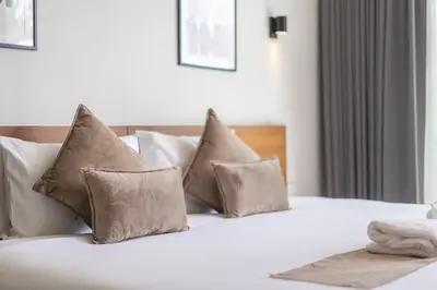 a white bed with four pillows on top of it at \u5bbd\u655e\u8212\u9002 \u90a6\u6d9b\u6d77\u6ee9Laguna\u9644\u8fd1 \u4e09\u5367\u5ba4\u79c1\u4eba\u6cf3\u6c60\u522b\u5885 in Phuket Town