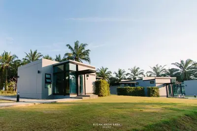 a house with a green lawn in front of it at Bulan Anda Resort in Ban Hua Laem