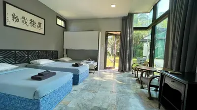 a hotel room with two beds and a table and chairs at Bulan Anda Resort in Ban Hua Laem