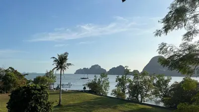 a view of a body of water with a palm tree at Bulan Anda Resort in Ban Hua Laem
