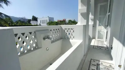 a balcony with a white railing and a view of a building at Little Nyonya Hotel in Phuket Town