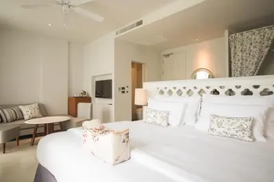 a bedroom with a large white bed and a couch at Little Nyonya Hotel in Phuket Town