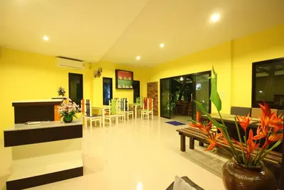 a living room with yellow walls and a table and chairs at Bida Daree Resort in Ao Nang Beach