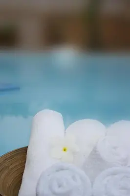 a bunch of white towels with a flower on them at Bida Daree Resort in Ao Nang Beach