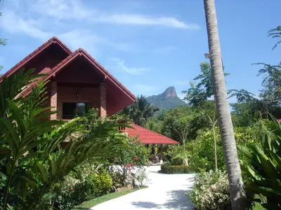 a resort with a mountain in the background at Cliffside Lagoon Villa in Ao Nang Beach