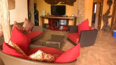 a living room with red furniture and a television at Cliffside Lagoon Villa in Ao Nang Beach