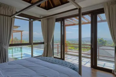 a bedroom with a bed and a view of a pool at \u67e5\u9f993\u5367\u5ba4\u534a\u5c71\u6d77\u666f\u522b\u5885 in Ban Na Kok