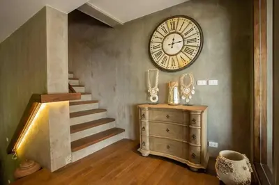 a room with a staircase and a clock on the wall at \u67e5\u9f993\u5367\u5ba4\u534a\u5c71\u6d77\u666f\u522b\u5885 in Ban Na Kok
