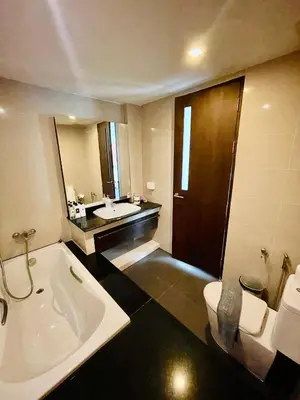 a bathroom with a tub and a toilet and a sink at The Kris Residence Two Bedrooms Apartment in Patong Beach
