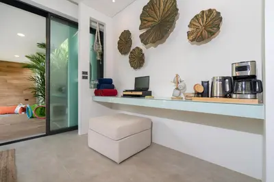 a room with a counter with a stool in it at Villa Kalliste Phuket - Lush Garden Escape in Nai Yang Beach