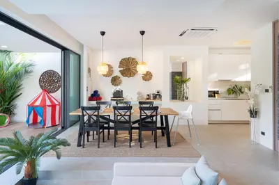 a dining room and kitchen with a table and chairs at Villa Kalliste Phuket - Lush Garden Escape in Nai Yang Beach