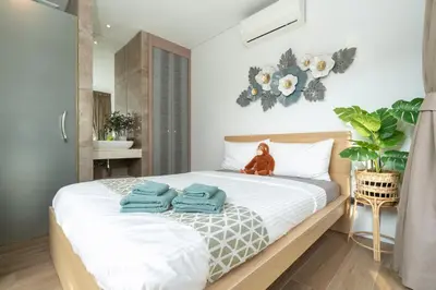 a bedroom with a bed with blue towels on it at Villa Kalliste Phuket - Lush Garden Escape in Nai Yang Beach