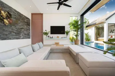a living room with a couch and a tv at Villa Kalliste Phuket - Lush Garden Escape in Nai Yang Beach