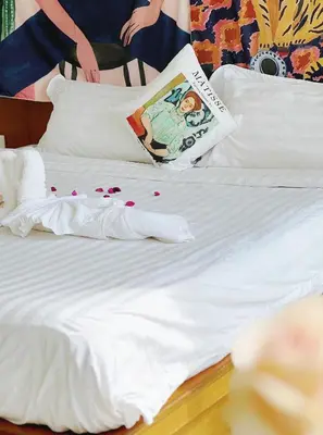 a bed with white sheets and pillows with hearts on it at Lanting House Phuket in Patong Beach
