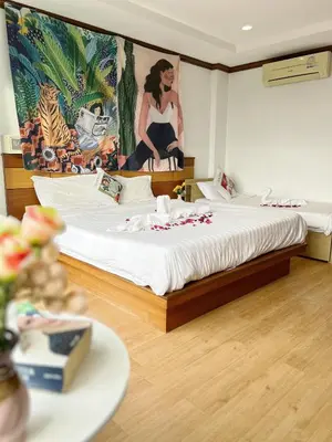 a bedroom with a bed with a painting on the wall at Lanting House Phuket in Patong Beach