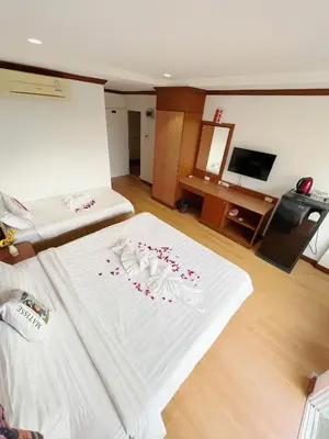 a bedroom with a white bed with flowers on it at Lanting House Phuket in Patong Beach