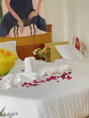 a bedroom with two beds with flowers on the bed at Lanting House Phuket in Patong Beach
