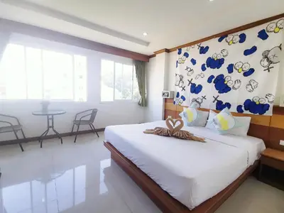 a bedroom with a large bed with a wall of plates at Lanting House Phuket in Patong Beach