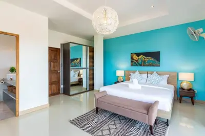 a bedroom with a large bed with a blue wall at V270 Best View In Phuket Hot Tub Great Location in Rawai Beach