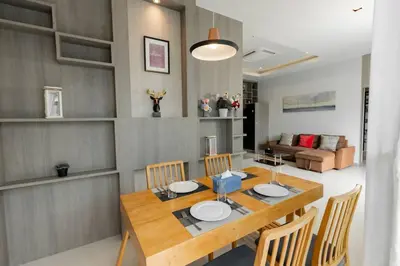 a dining room with a wooden table and chairs at Udomsuk Pool Villa Krabi in Ban Khlong Haeng