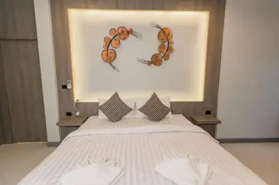 a bedroom with a bed with two antlers on the wall at Udomsuk Pool Villa Krabi in Ban Khlong Haeng