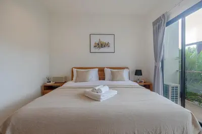 a bedroom with a bed with two towels on it at Uncle Toy in Ban Riang