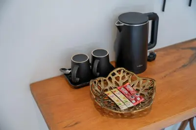 a table with a coffee pot and a basket of candy at Uncle Toy in Ban Riang