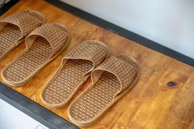 four pairs of wicker shoes sitting on a table at Uncle Toy in Ban Riang