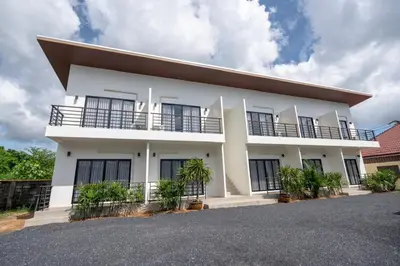 a white house with black windows at Uncle Toy in Ban Riang