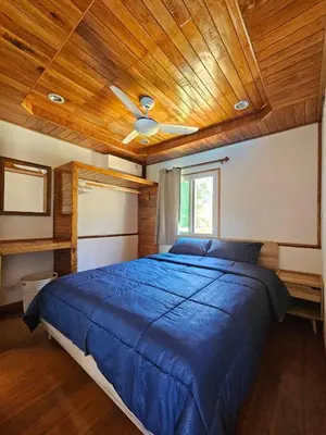 a bedroom with a blue bed with a wooden ceiling at Tiny 1-2 in Rawai Beach