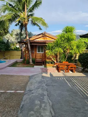 a house with a picnic table and palm trees at Tiny 1-2 in Rawai Beach