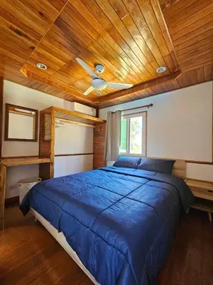 a bedroom with a blue bed with a wooden ceiling at Tiny 1-2 in Rawai Beach
