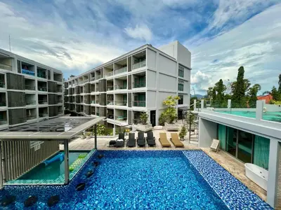 an apartment complex with a swimming pool and a building at The Regent Bangtao by RESAVA in Bang Tao Beach