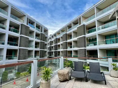 an apartment building with two chairs on the balcony at The Regent Bangtao by RESAVA in Bang Tao Beach