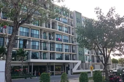 a large building with trees in front of it at Stylish condo near Boat Avenue LAGUNA in Bang Tao Beach