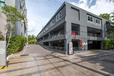 a large gray building with a parking lot at Apartment in Mida Grande Surin in Surin Beach