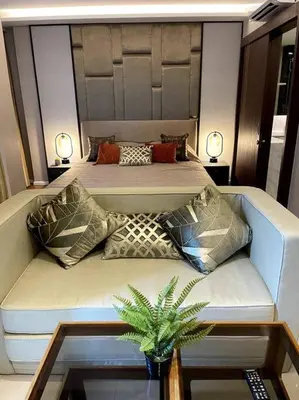 a bedroom with two beds and a couch with pillows at Apartment in Mida Grande Surin in Surin Beach