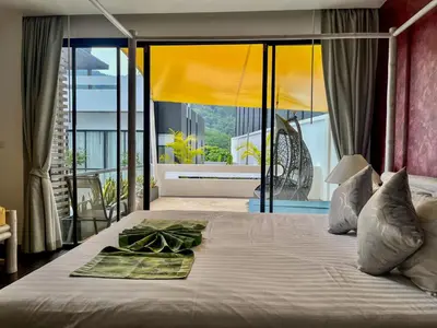 a bedroom with a bed with a view of a balcony at Naiharn Pool Villa Number 5 in Rawai Beach