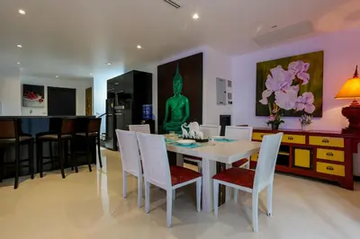 a kitchen and dining room with a table and chairs at Naiharn Pool Villa Number 5 in Rawai Beach