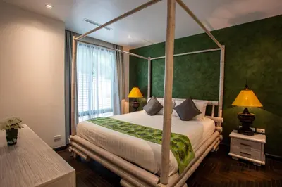 a bedroom with a four poster bed with green walls at Naiharn Pool Villa Number 5 in Rawai Beach